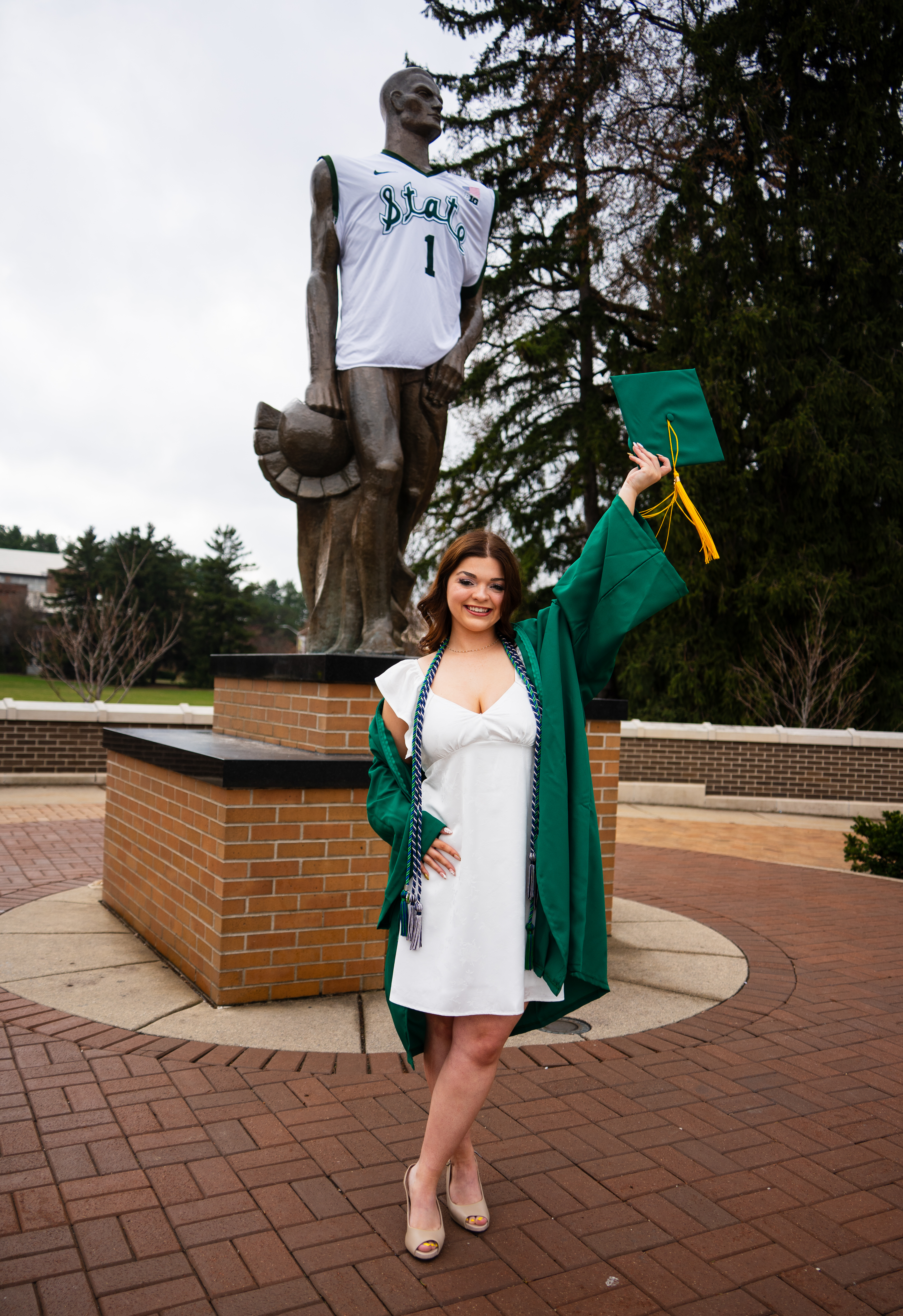 Graduation photo of Bella Hilden by the Sparty Statue on Michigan State University's campus.