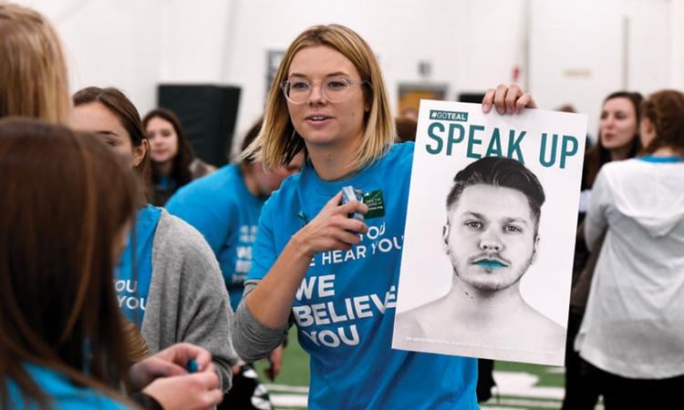 Student with a Go Teal Poster