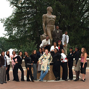 students pose around The Spartan statue