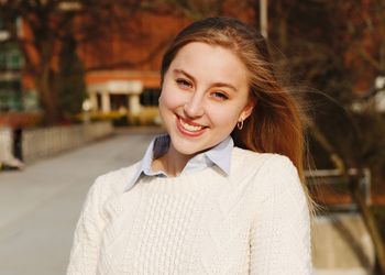 Emma Frick stands in front of the MSU Libraries on a fall day