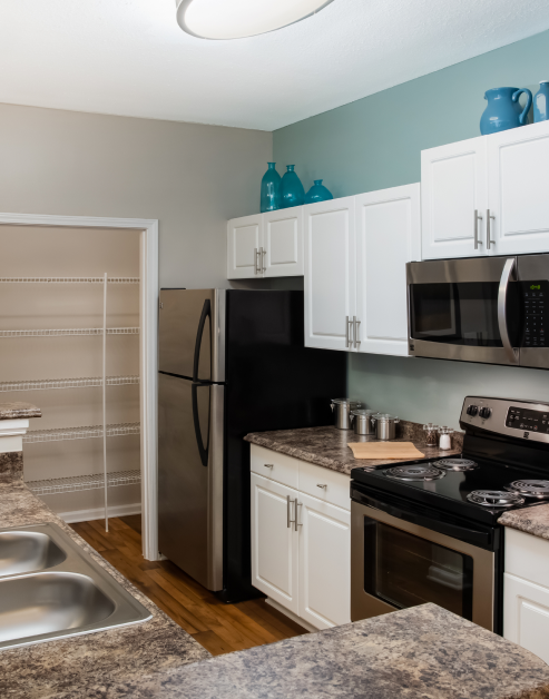 Modern kitchen with white cabinets, granite countertops and updated appliances at MAA Barrett Creek luxury apartments in Marietta, GA