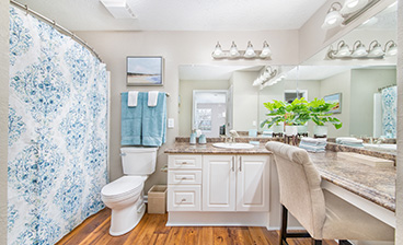 Spacious bathroom with patterned shower curtains, powder sitting area with large vanity mirrors at MAA Berkeley Lake luxury apartments in Duluth, GA