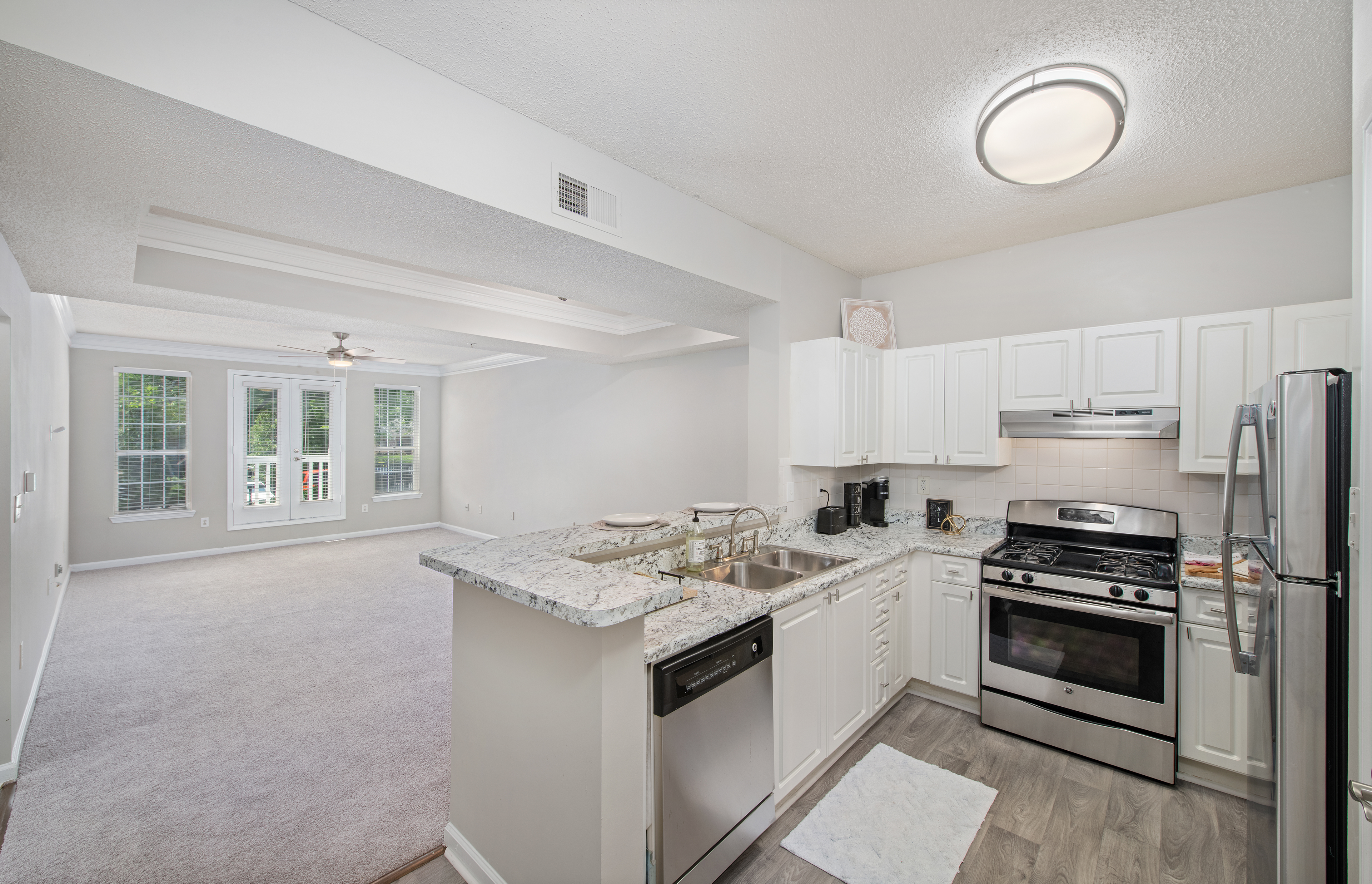 Kitchen view of open living room in model unit property at MAA Briarcliff luxury apartments in Atlanta, GA