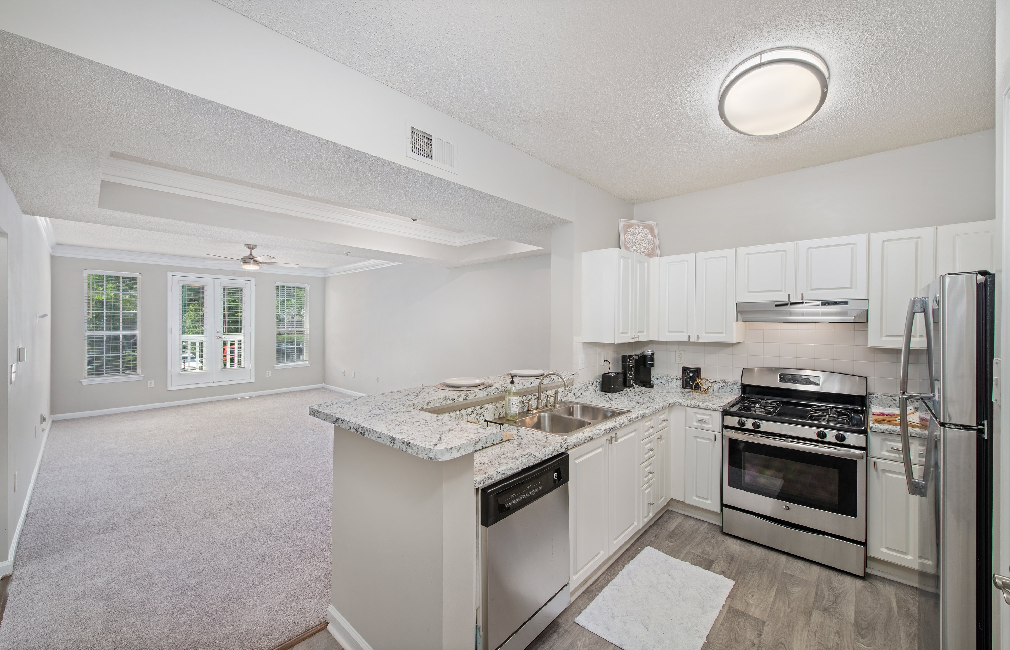 Kitchen view of open living room in model unit property at MAA Briarcliff luxury apartments in Atlanta, GA
