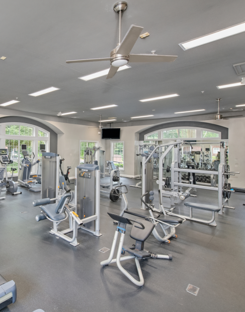 Fully equipped fitness center with stationary bikes, weight machines and a wall-mounted TV at MAA Briarcliff luxury apartments in Atlanta, GA