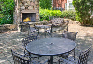 Patio area with tables and chairs by an outdoor fireplace at MAA Briarcliff luxury apartments in Atlanta, GA