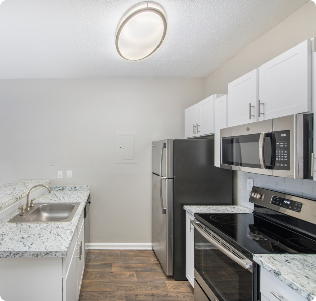 Modern open kitchen with wood floors and stainless steel appliances at MAA Brookhaven luxury apartments in Atlanta, GA