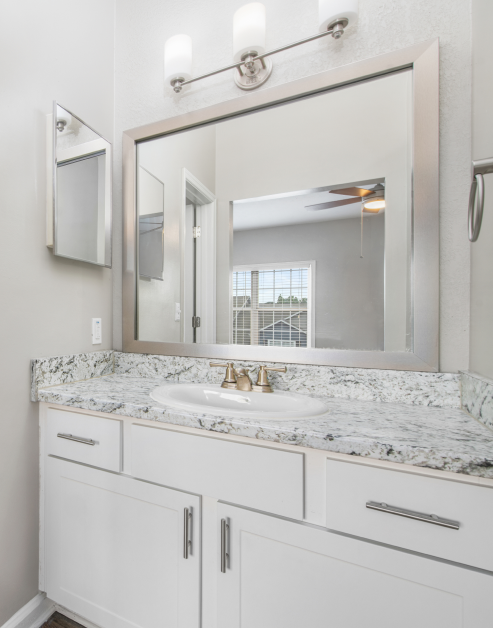 Modern-style white bathroom with a single vanity sink and large vanity mirror at MAA Brookhaven luxury apartments in Atlanta, GA