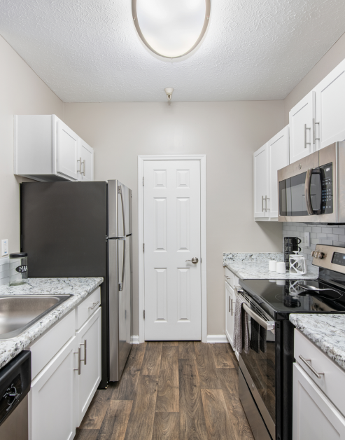 Modern-style kitchen with white cabinets and stainless steel appliances at MAA Brookhaven luxury apartments in Atlanta, GA
