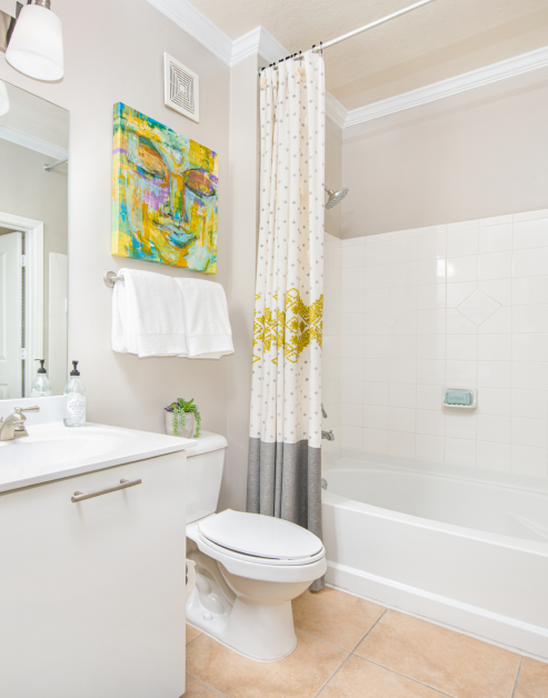White bathroom with a single vanity sink and bathtub with colorful accents at MAA Brookwood luxury apartments in Atlanta, GA