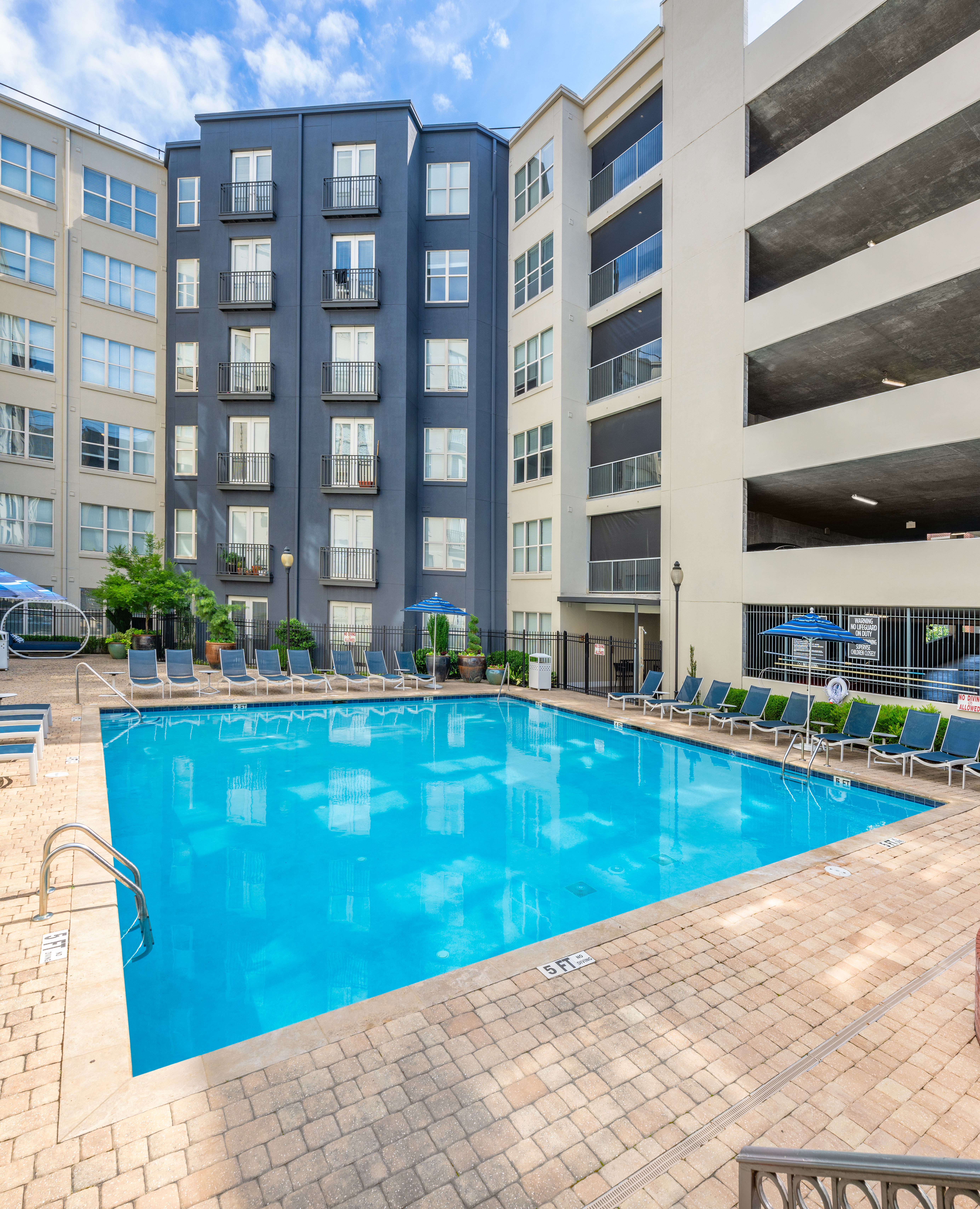 Swimming pool with lounge chairs centered in middle of the apartment complex at MAA Buckhead luxury apartments complex in Atlanta, GA