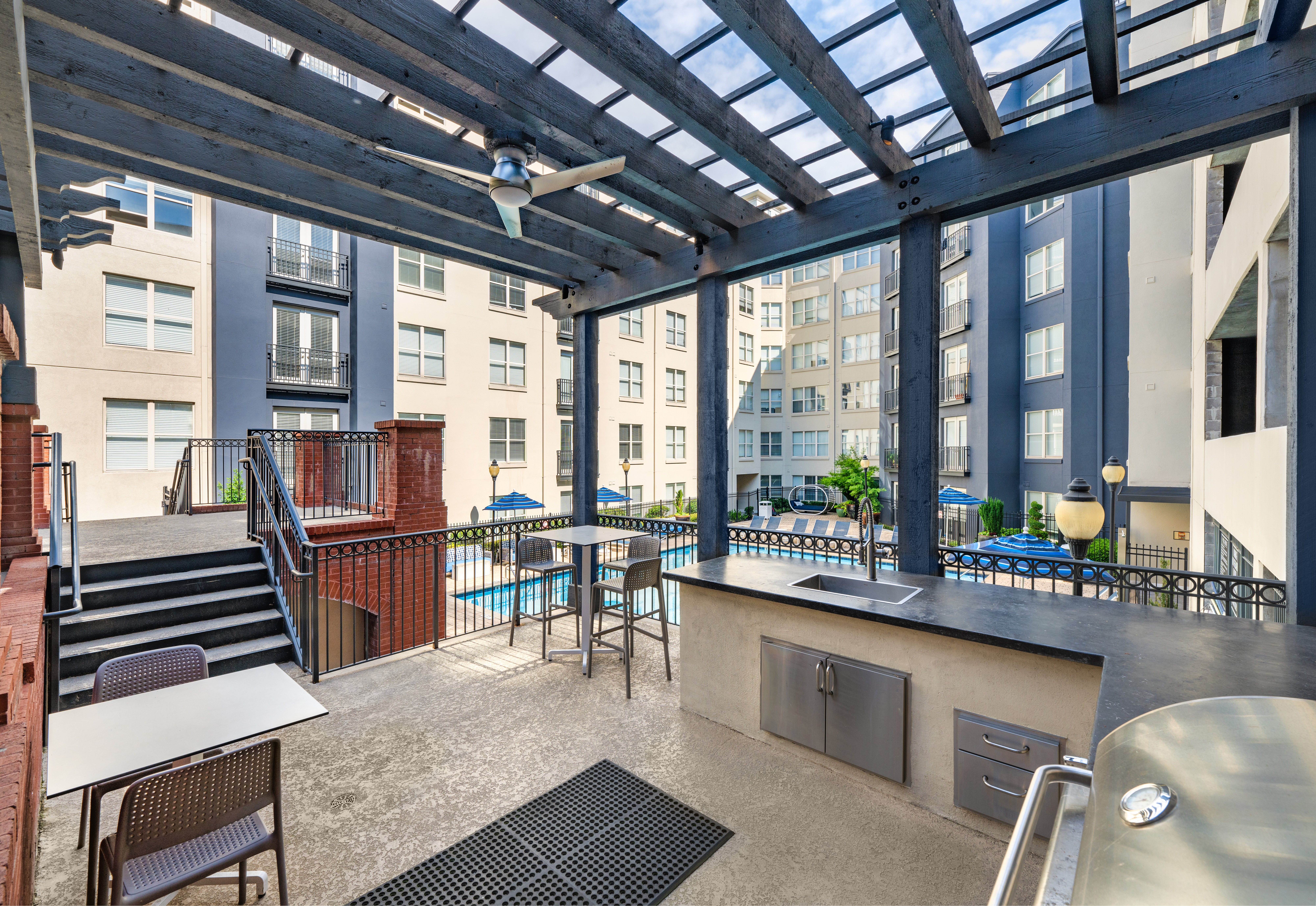 Outdoor grilling station under wooden pergola next to the swimming pool at MAA Buckhead luxury apartments complex in Atlanta, GA