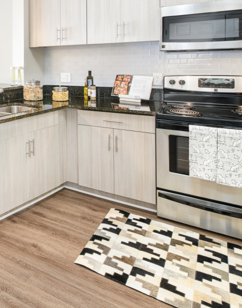 Modern kitchen with grey cabinets, upgraded appliances and dark countertops at MAA Buckhead luxury apartments in Atlanta, GA
