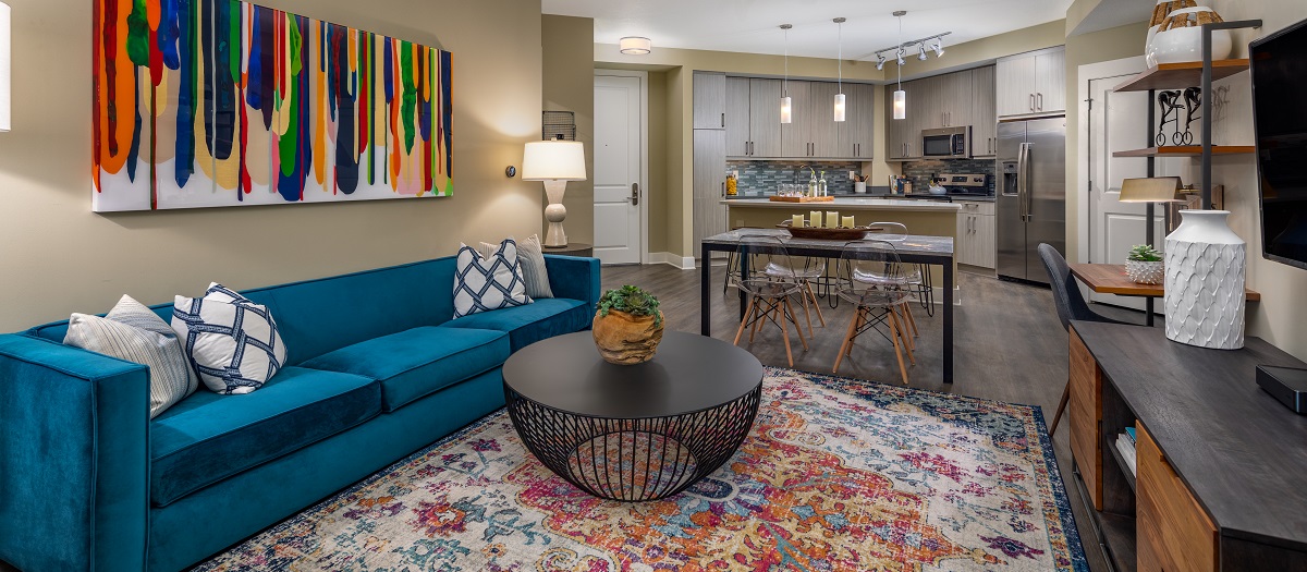 Open living space in model home with blue couch and coffee table at MAA Centennial Park luxury apartments in Atlanta, GA