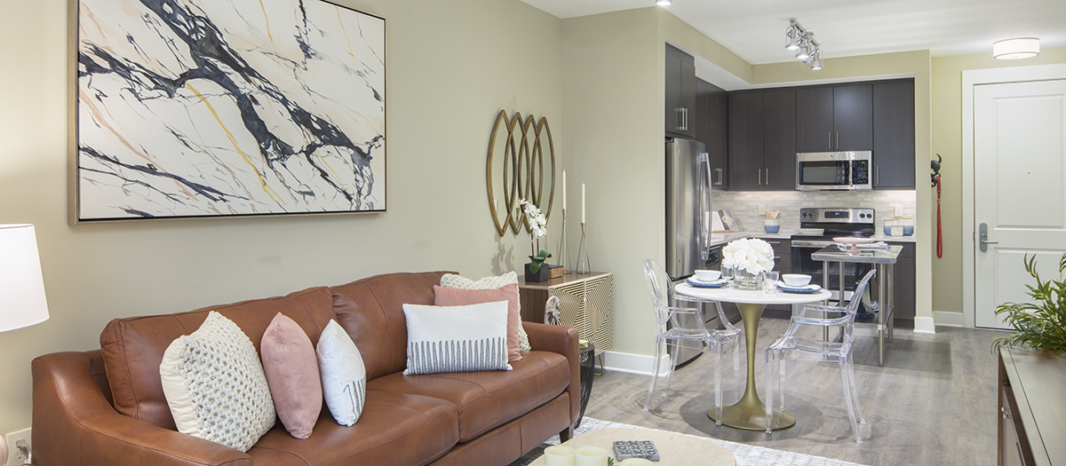 Living space in second model home with brown couch and dining table at MAA Centennial Park luxury apartments in Atlanta, GA