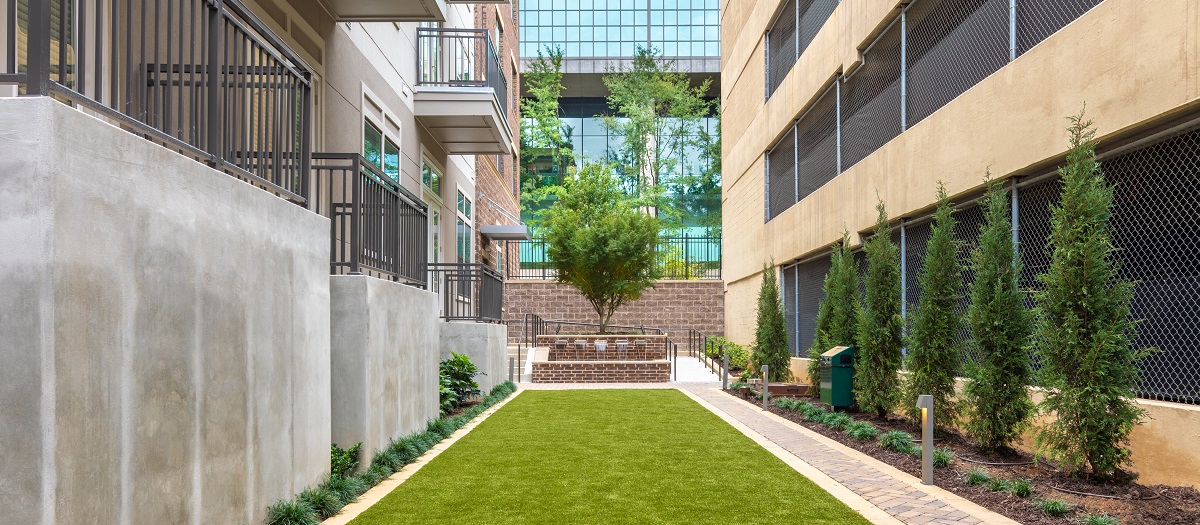 Pet-friendly park with greenery nestled between units at MAA Centennial Park luxury apartments in Atlanta, GA