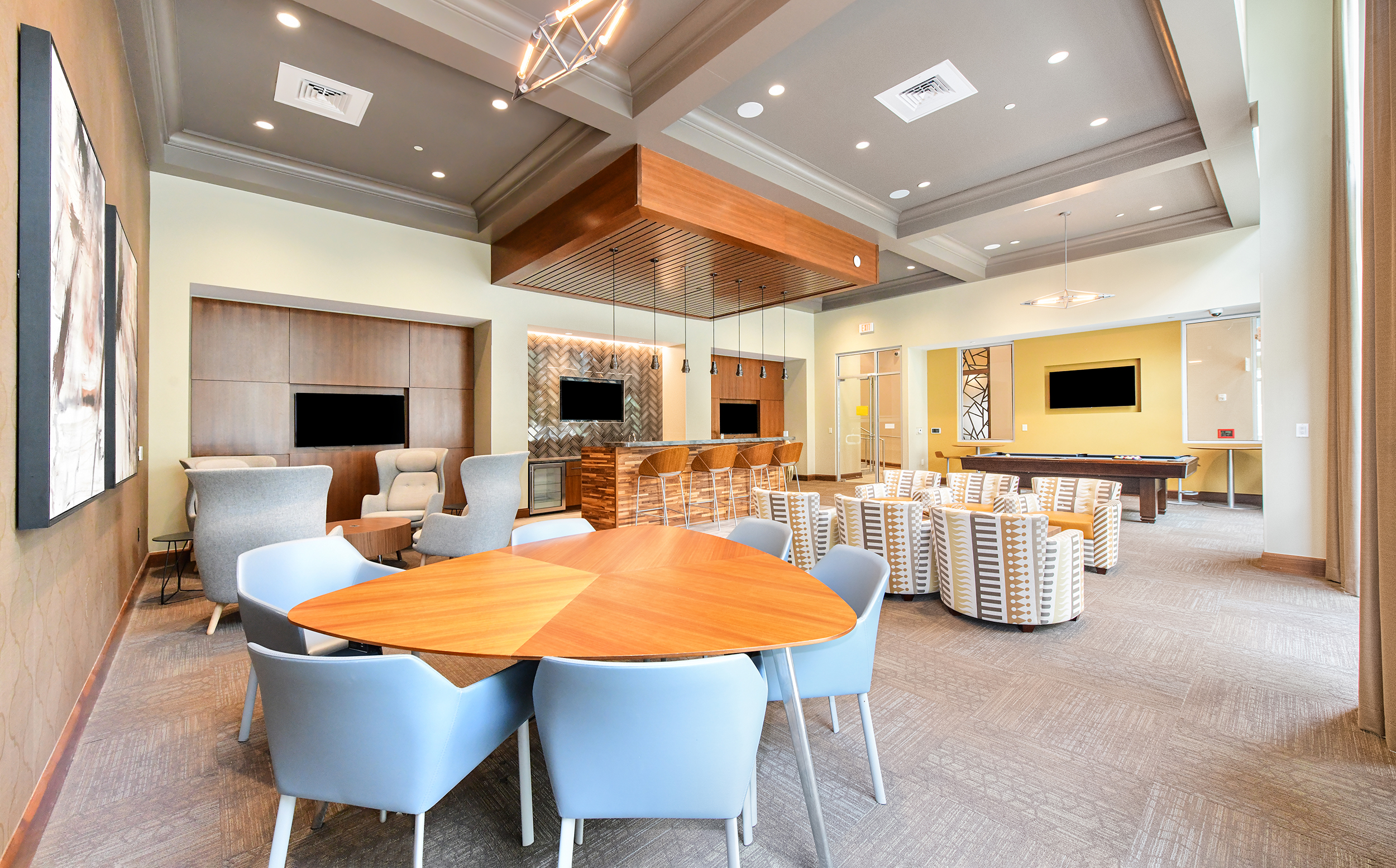 Streetside terrace community center with tables and chairs and multiple TV stations at MAA Centennial Park luxury apartments in Atlanta, GA