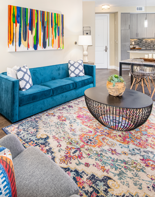 Living room space in model home with blue couch and coffee table at MAA Centennial Park luxury apartments in Atlanta, GA