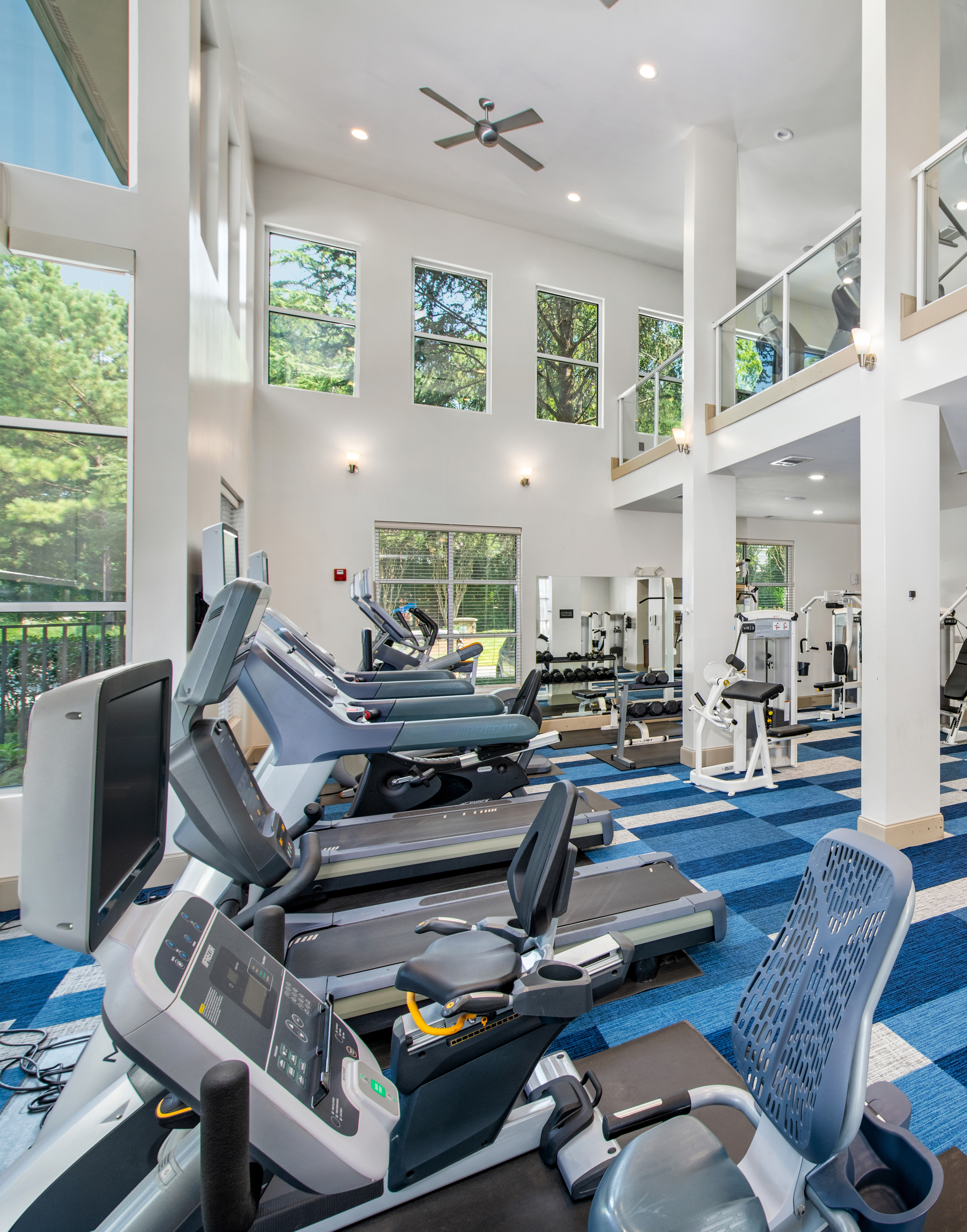 State-of-the-art two story fitness center complete with treadmills and weight machines next to large picture windows at MAA Chastain luxury apartments in Atlanta, GA