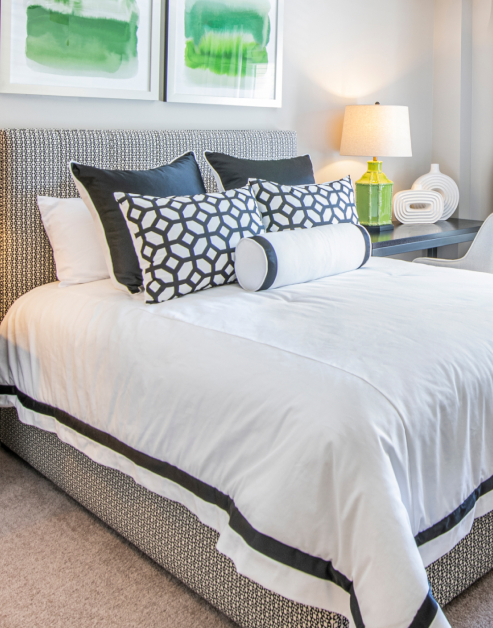 Cozy bedroom with black and white bedding and accent pillows and writing desk at MAA Chastain luxury apartments in Atlanta, GA
