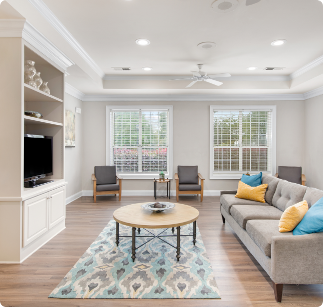 Spacious lounge with hard wood floors, built-in entertainment wall and picture windows at MAA Dunwoody luxury apartments in Atlanta, GA