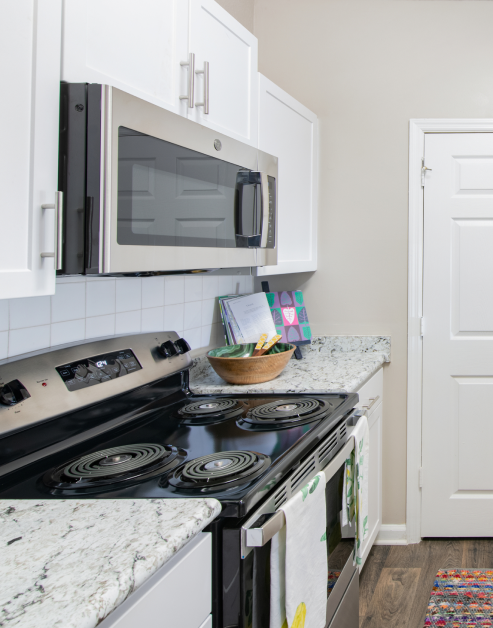 Modern kitchen with light countertops, white cabinets and upgraded cabinets at MAA Dunwoody luxury apartments in Atlanta, GA