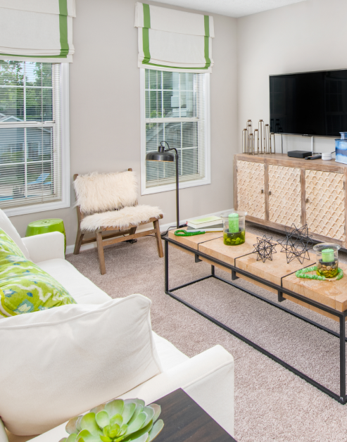 Upscale retro model living room with sitting area next to tall window views at MAA Dunwoody luxury apartments in Atlanta, GA