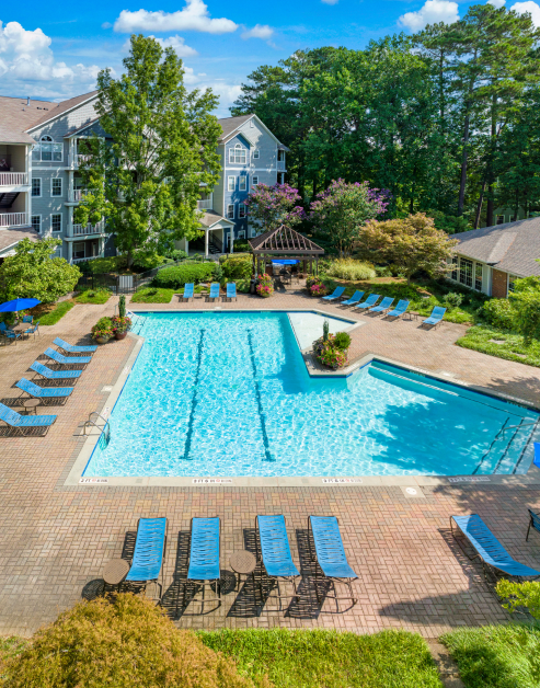 Resort-style swimming pool surrounded by lounge chairs and lush greenery at MAA Dunwoody luxury apartments in Atlanta, GA
