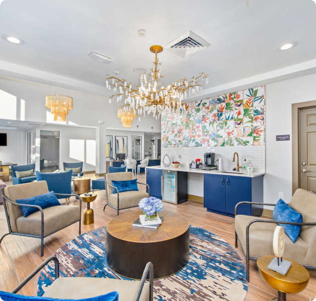 Luxurious community clubhouse sitting area around circular coffee table and coffee bar counter at MAA Gardens luxury apartments in Atlanta, GA