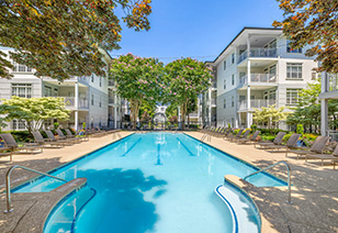 Long view of swimming pool with lounge chairs surrounded by trees at MAA Gardens luxury apartments in Atlanta, GA