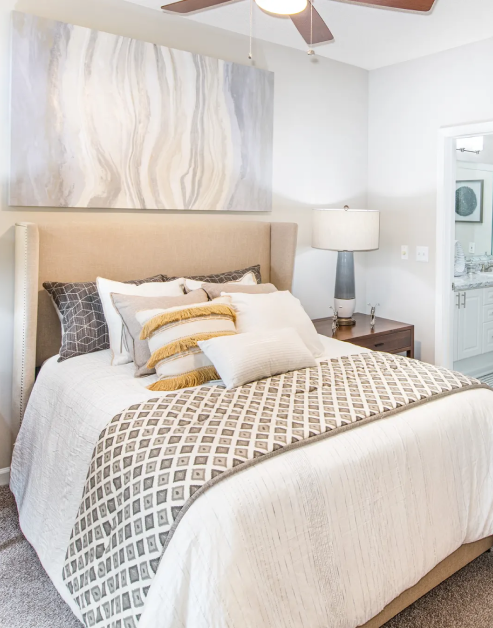 Model bedroom with bedside night stand and ceiling fan at MAA Gardens luxury apartments in Atlanta, GA