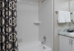 Bathroom with shower tub and patterned shower curtains at MAA Glen luxury apartments in Atlanta, GA