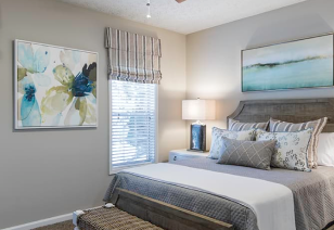 Model bedroom with picture window and colorful wall art at MAA Glen luxury apartments in Atlanta, GA