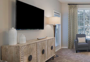 Stylish living room side view with tan entertainment center and wall-mounted TV at MAA Glen luxury apartments in Atlanta, GA