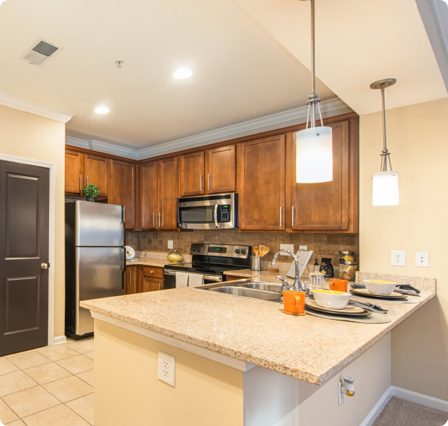 Modern-style kitchen with brown cabinets and stainless steel appliances at MAA Lenox luxury apartments in Atlanta, GA