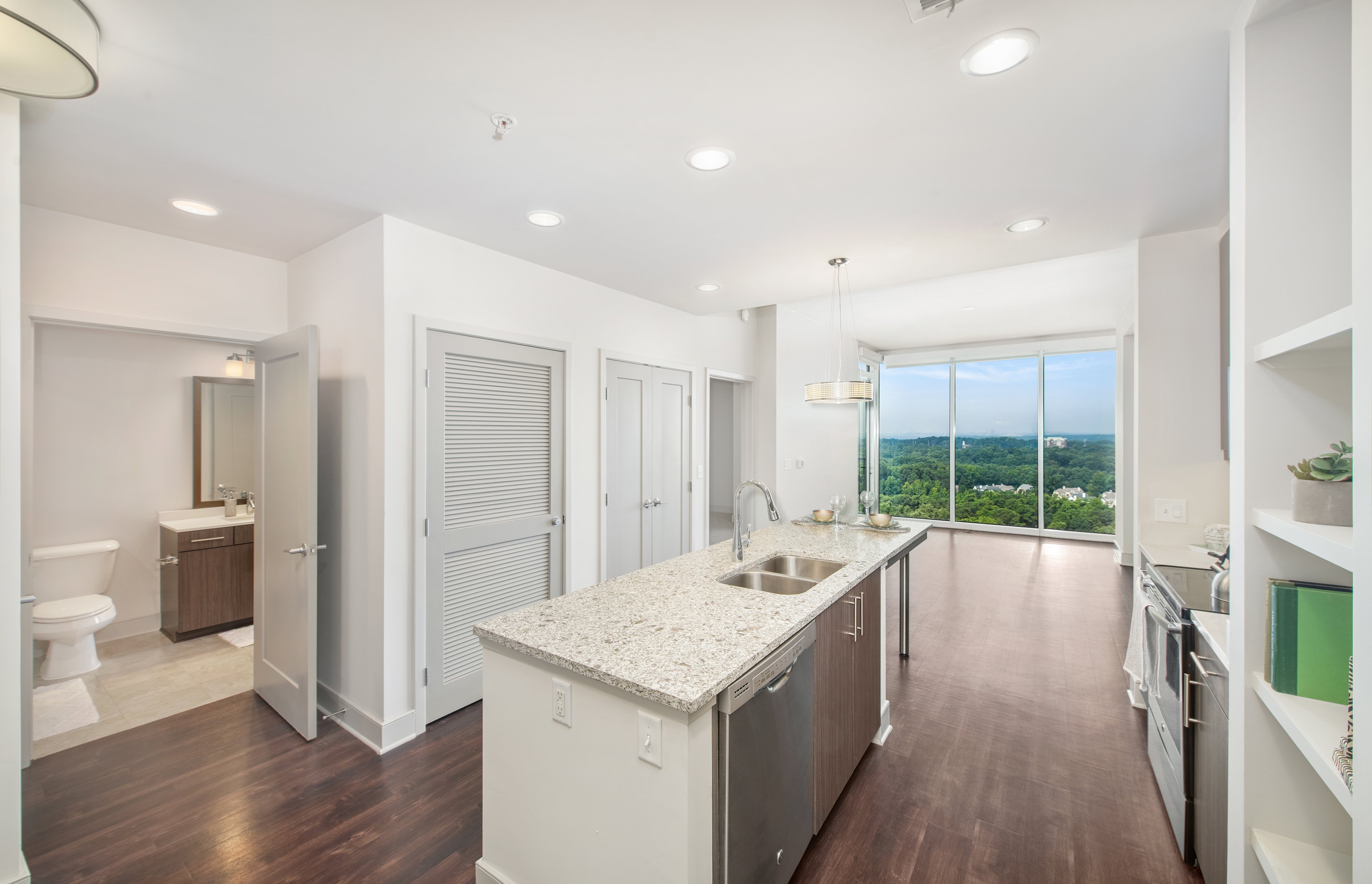 Upscale modern-style kitchen with island and open floorplan dining area with skyline view at MAA Lenox luxury apartments in Atlanta, GA
