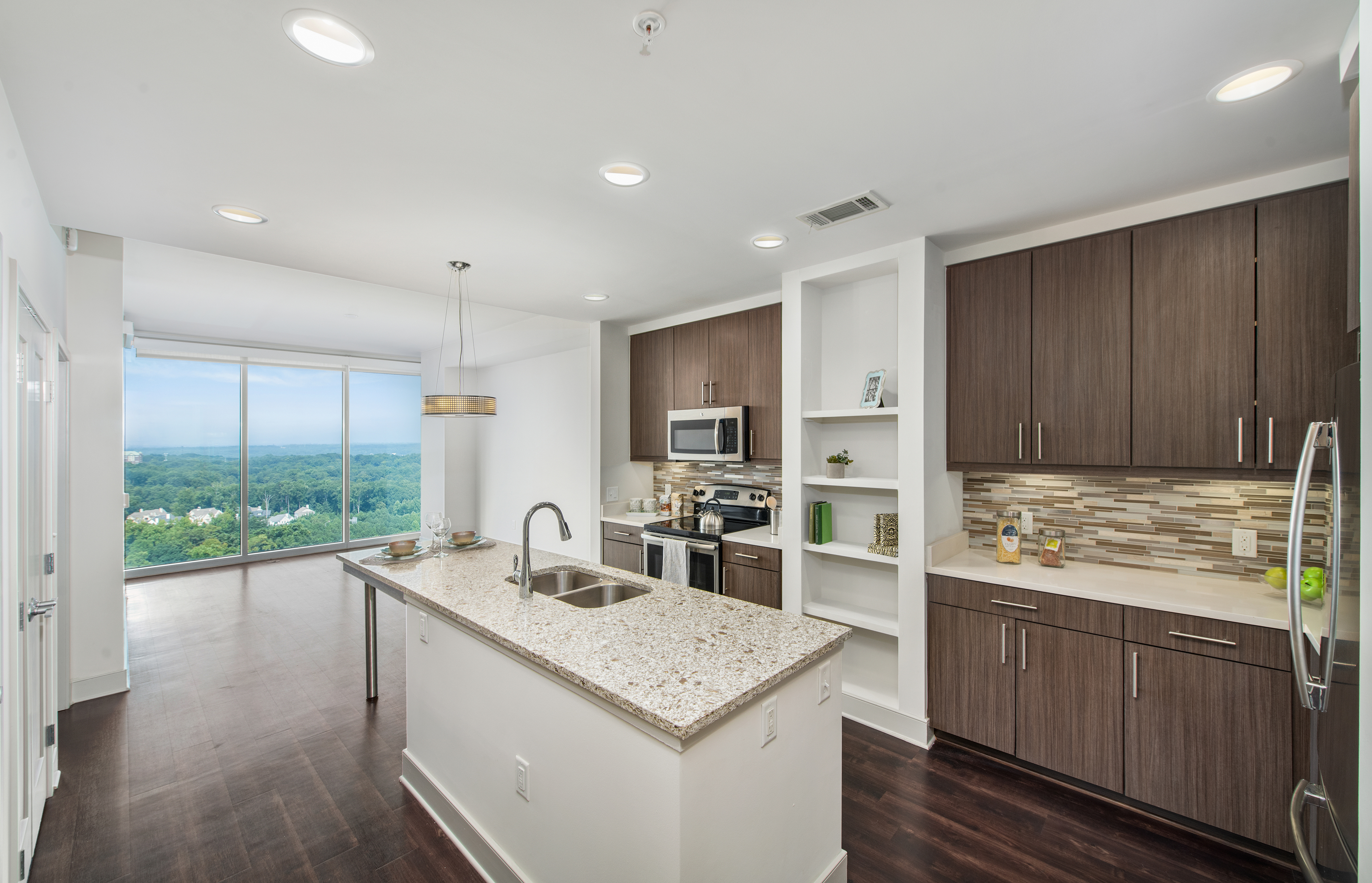 Upscale modern-style kitchen with island and open floorplan dining area with skyline view at MAA Lenox luxury apartments in Atlanta, GA