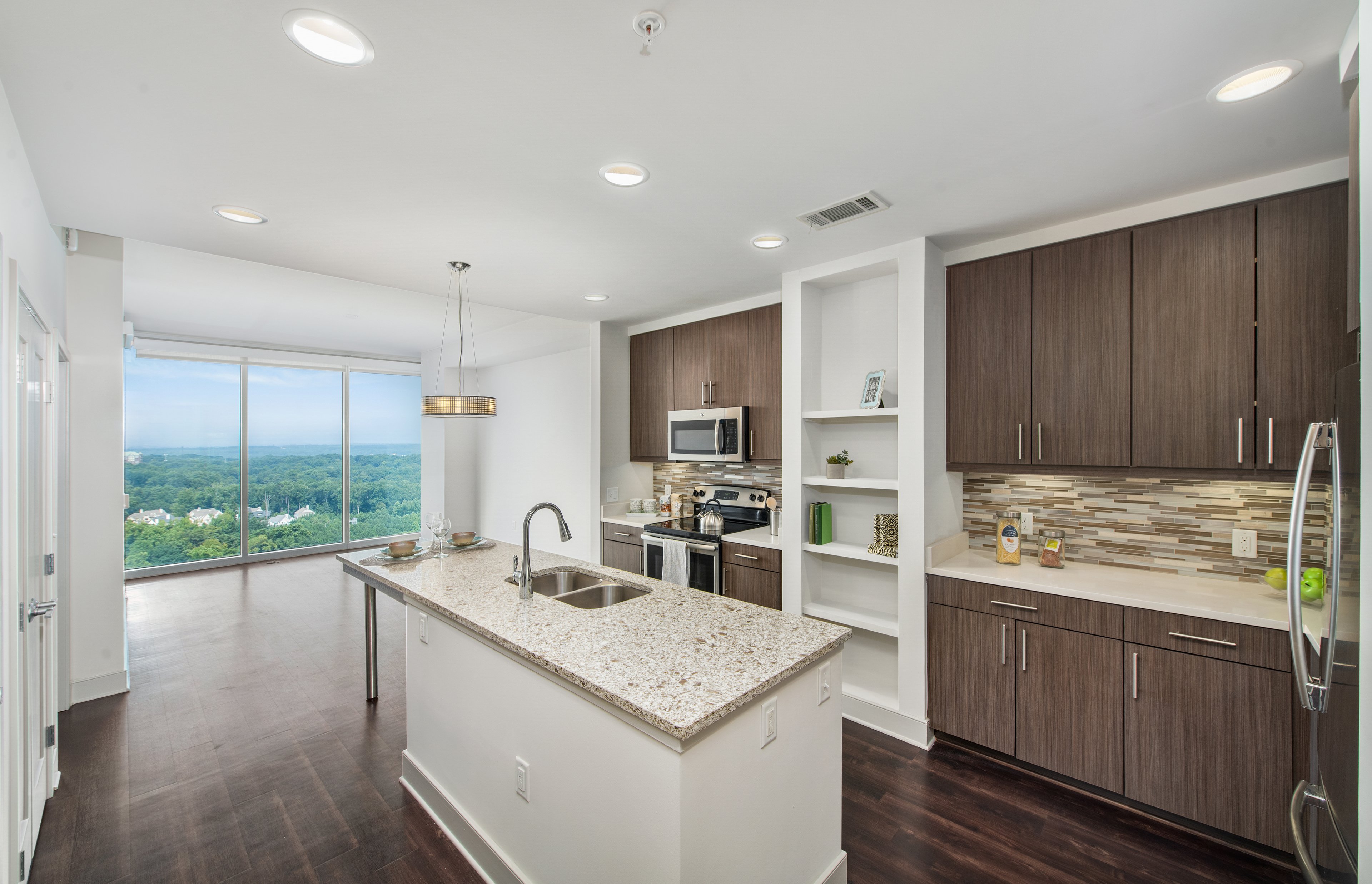 Upscale modern-style kitchen with island and open floorplan dining area with skyline view at MAA Lenox luxury apartments in Atlanta, GA