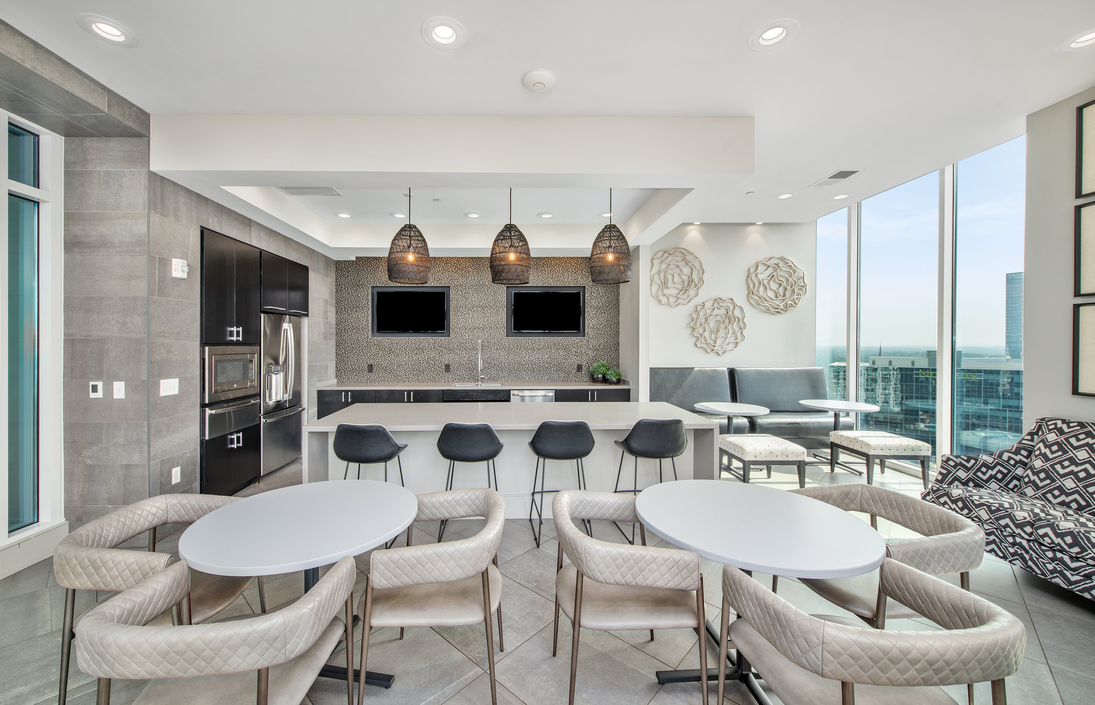 Rooftop clubhouse with an industrial kitchen and cozy dining area with TVs at MAA Lenox luxury apartments in Atlanta, GA