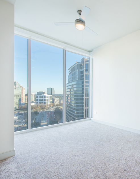 Wide open carpeted bedroom space with skyline window view at MAA Lenox luxury apartments in Atlanta, GA