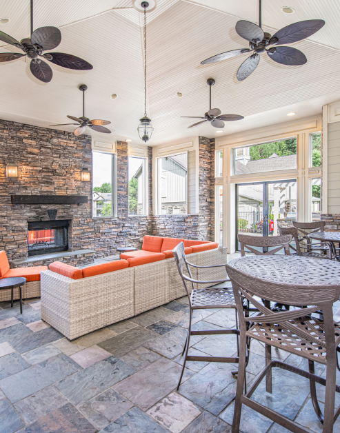 Clubhouse indoor common area with large picture windows and lounge area next to fireplace at MAA McDaniel Farm luxury apartments in Duluth, GA