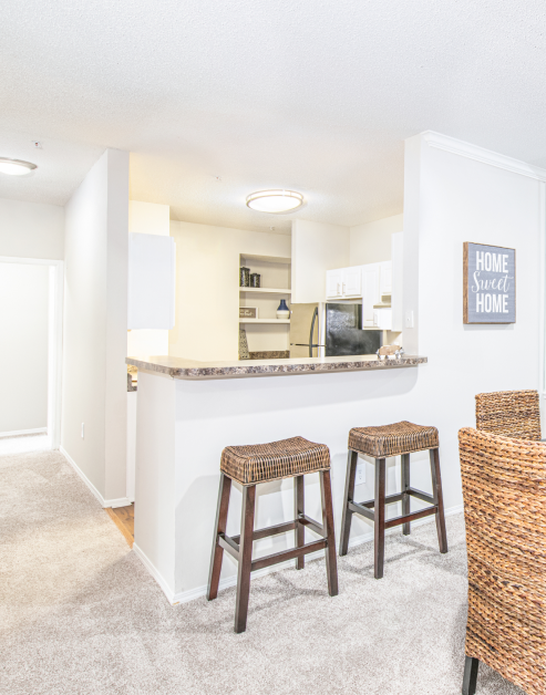 Kitchen with granite counter bar top with wicker bar stools at MAA McDaniel Farm luxury apartments in Duluth, GA