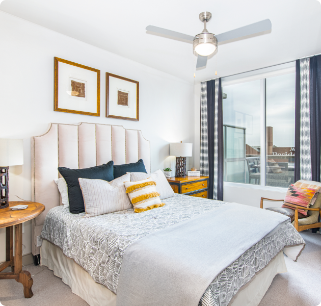 Upscale apartment bedroom with modern décor and window view of outside balcony at MAA Midtown luxury apartments in Atlanta, GA