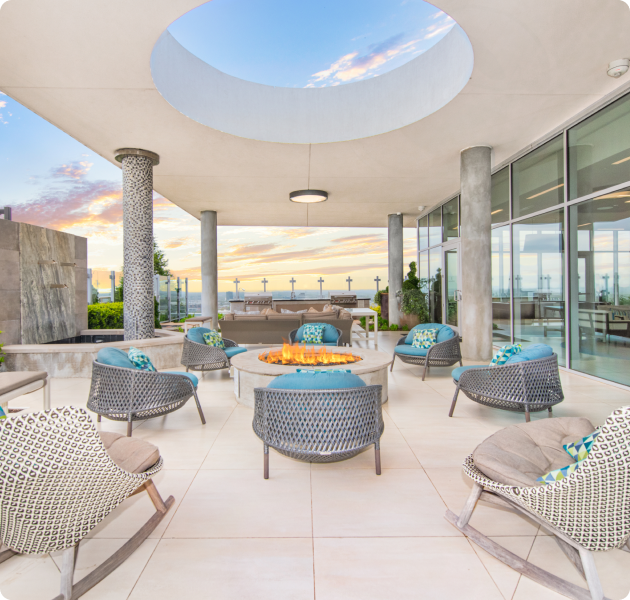 Community stylish rooftop sky lounge covered sitting area with firepit and skyline views at MAA Midtown luxury apartments in Atlanta, GA