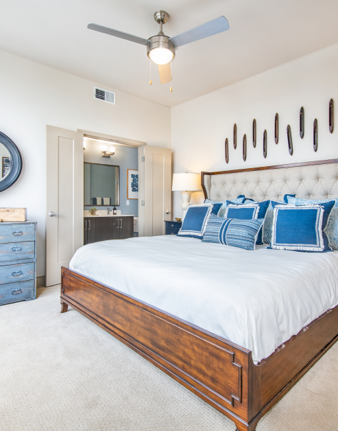 Model master bedroom with en suite bathroom and ceiling fan at MAA Midtown luxury apartments in Atlanta, GA