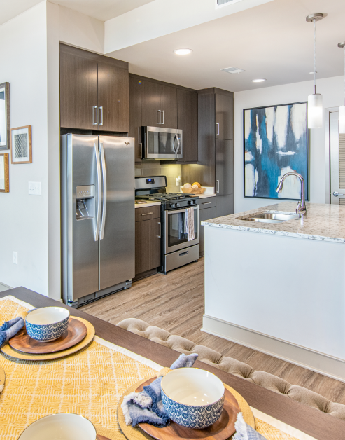 Upscale modern kitchen with stylish brown cabinets, hard floors and upgraded appliances at MAA Midtown luxury apartments in Atlanta, GA