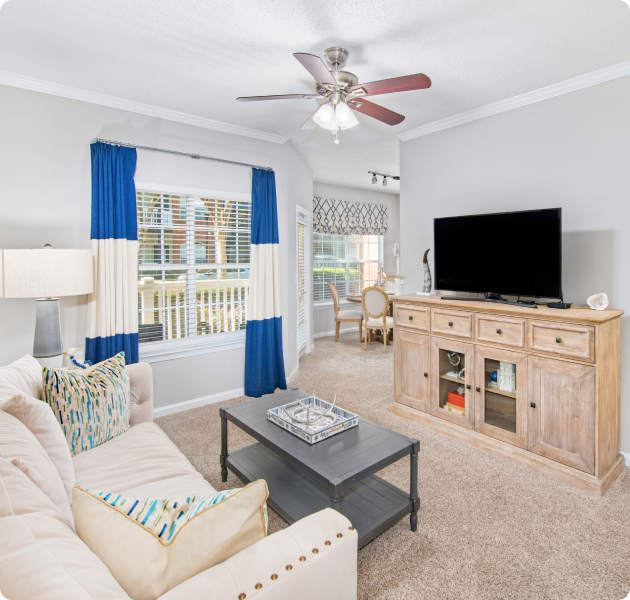 Stylish model living room with white furniture and ceiling fan at MAA Milstead luxury apartments in Kennesaw, GA