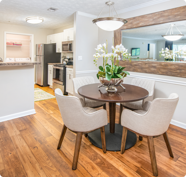 Model dining room with round wooden dining table and chairs, with wood floors at MAA Mount Vernon luxury apartments in Sandy Springs, GA