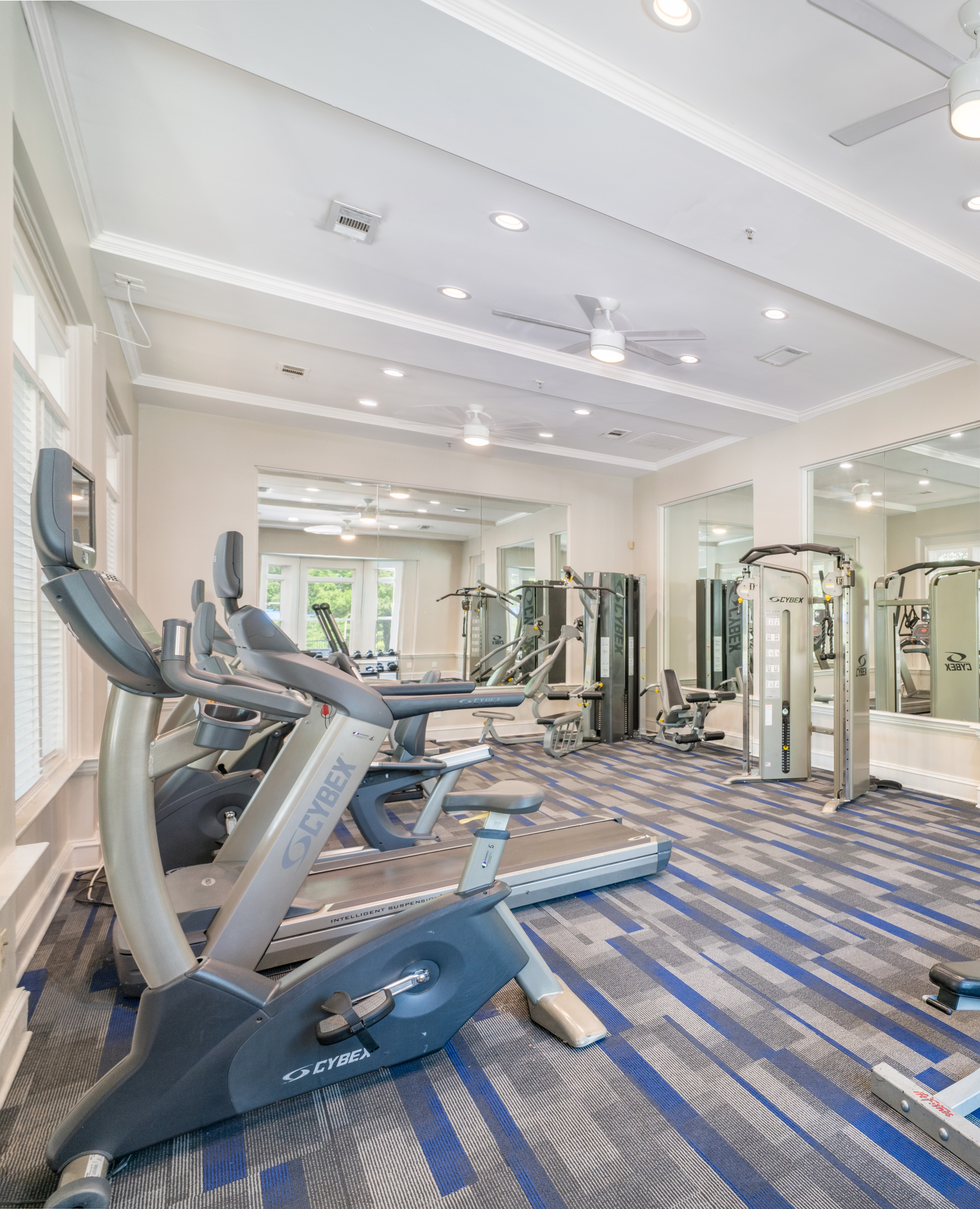Carpeted community fitness center with ceiling fans, treadmills and weight machines at MAA Mount Vernon luxury apartments in Sandy Springs, GA