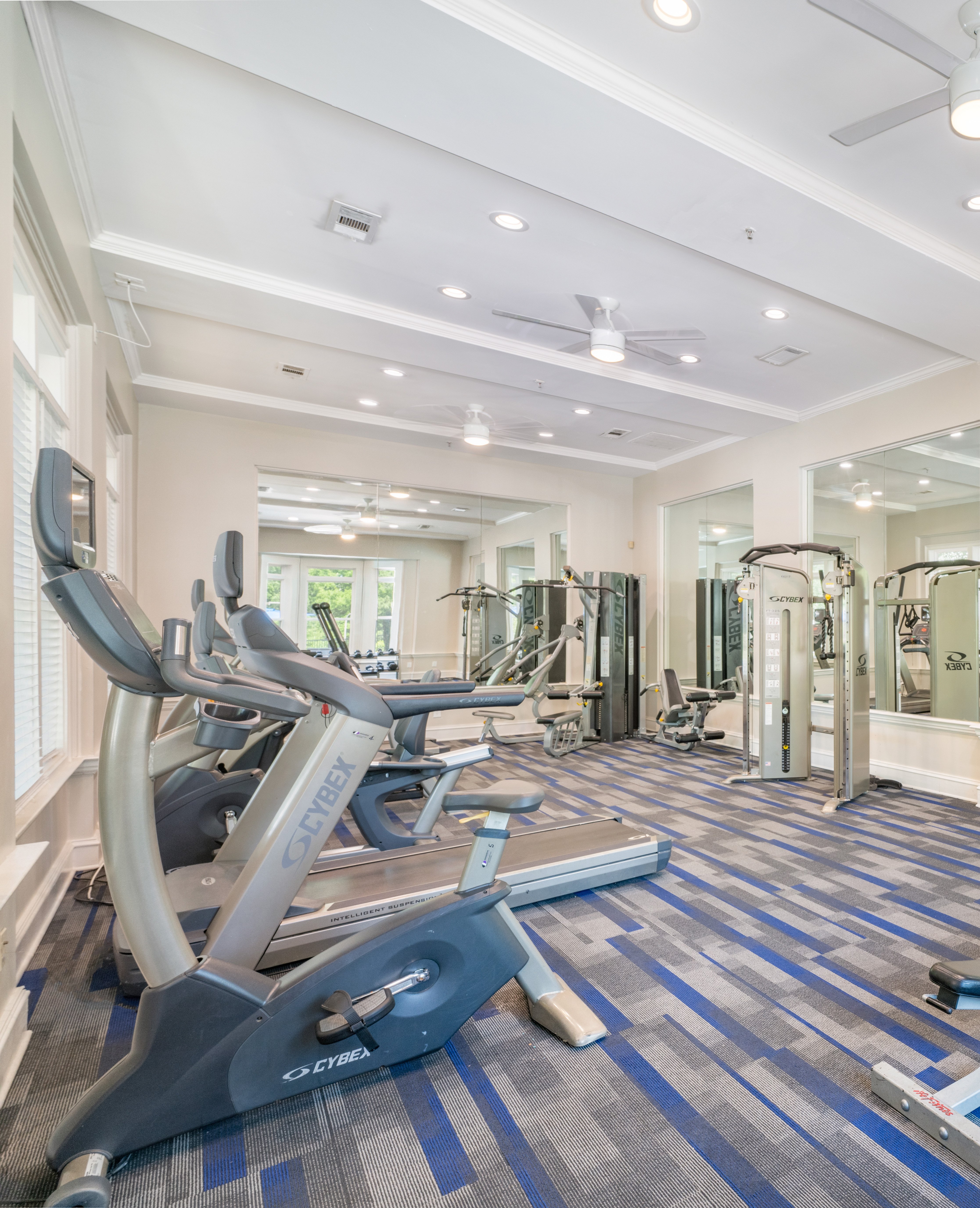 Carpeted community fitness center with ceiling fans, treadmills and weight machines at MAA Mount Vernon luxury apartments in Sandy Springs, GA